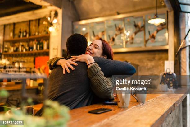 mujer joven emocionada abrazando a su novio después de mucho tiempo sin ver y finalmente puede sentir alivio - reencuentro fotografías e imágenes de stock