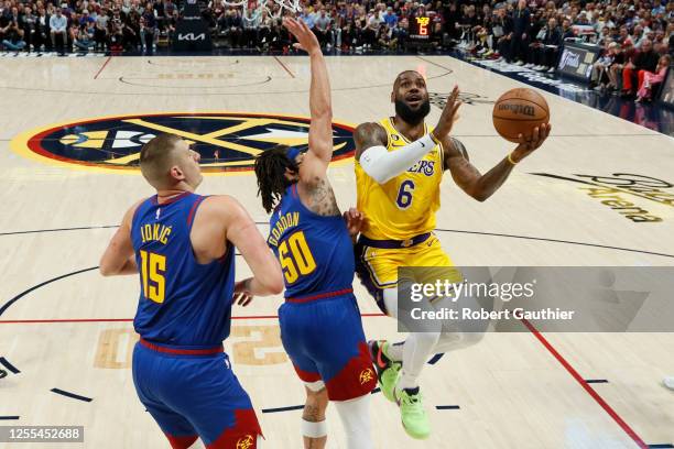 Denver, CO, Tuesday, May 16, 2023 - Los Angeles Lakers forward LeBron James drives to the basket against Denver Nuggets forward Aaron Gordon and...