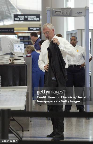 An unidentified airline traveler removes his jacket and shoes due to a new rule by the Transportation Security Administration Monday at Hobby Airport...