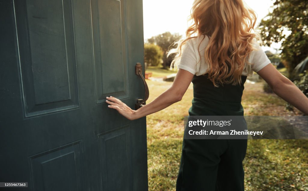 Happy woman jumping next to the open door. Nicely fits for book cover