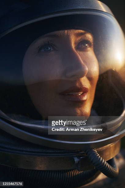 astronaut woman in space costume and helmet during sunset - casco da astronauta foto e immagini stock
