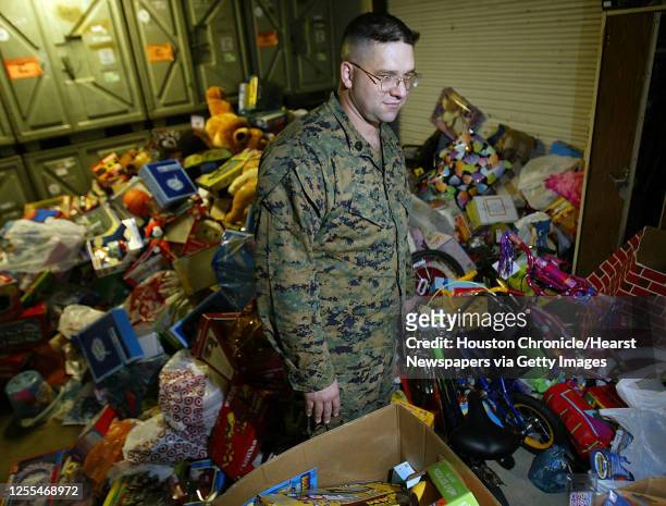Gunnery Sergeant Robert Belk looks over hundreds of toys collected for the annual Toys for Tots drive at the United States Marine Corps 1st...