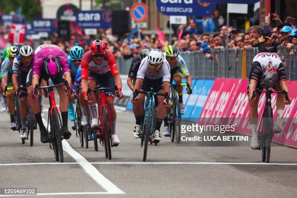 Team Emirates's German rider Pascal Ackermann crosses the finish line to win, ahead of Bahrain - Victorious's Italian rider Jonathan Milan and Astana...