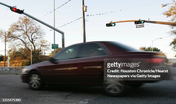 An automobile runs a red light at the intersection of Houston Avenue and Memorial Drive in Houston, Texas December 13,2004. James Nielsen