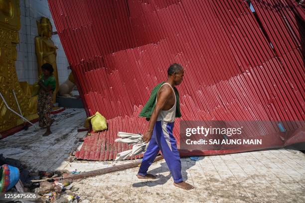 Man walks past the destroyed roof at a monastery in Sittwe on May 17 in the aftermath of Cyclone Mocha's landfall. The death toll in cyclone-hit...