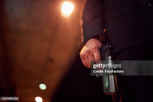 unrecognizable person holding a handgun at night - arma de fogo imagens e fotografias de stock