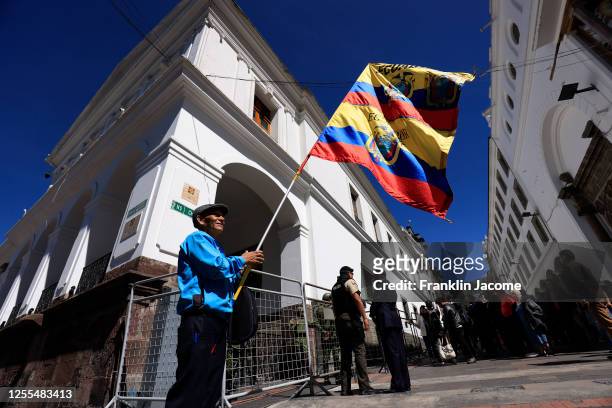 Man holds an Ecuadorian flag outside the Carondelet Government Palace on May 17, 2023 in Quito, Ecuador. Ecuadorian President Guillermo Lasso, who is...
