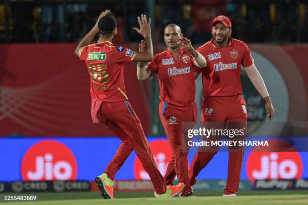 Punjab Kings' Shikhar Dhawan celebrates with teammates after taking a catch to dismiss Delhi Capitals' David Warner during the Indian Premier League...