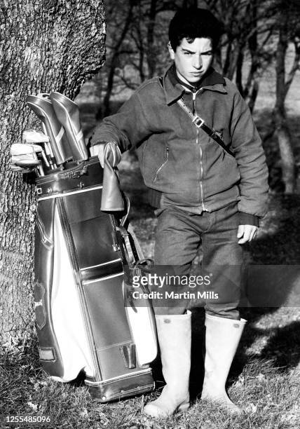 General view of a young golf caddie poses for a portrait with a golf bag circa 1966 in Rome, Italy.