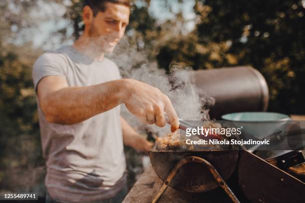 a man ready to grill in the yard - smoking meat stock pictures, royalty-free photos & images