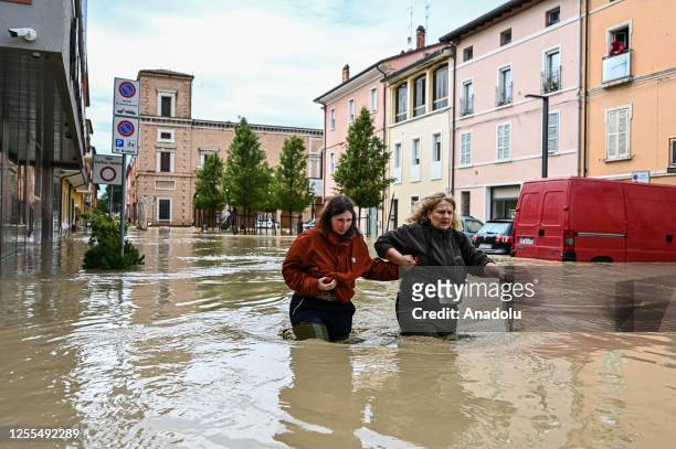Pedestrians walk in a flooded street in Castel Bolognese, near Imola, Italy on May 17, 2023. At least three people were killed and thousands of...