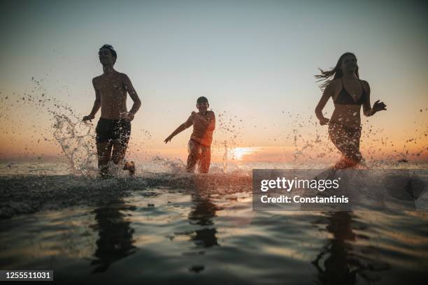 having fun on summer vacation - three girls at beach stock pictures, royalty-free photos & images