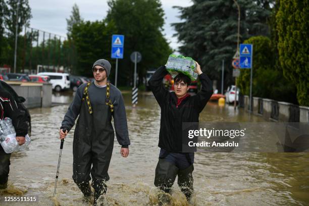 Citizen carries bottles of water after flood hits Castel Bolognese, Emilia-Romagna, Italy on May 17, 2023. At least three people were killed and...