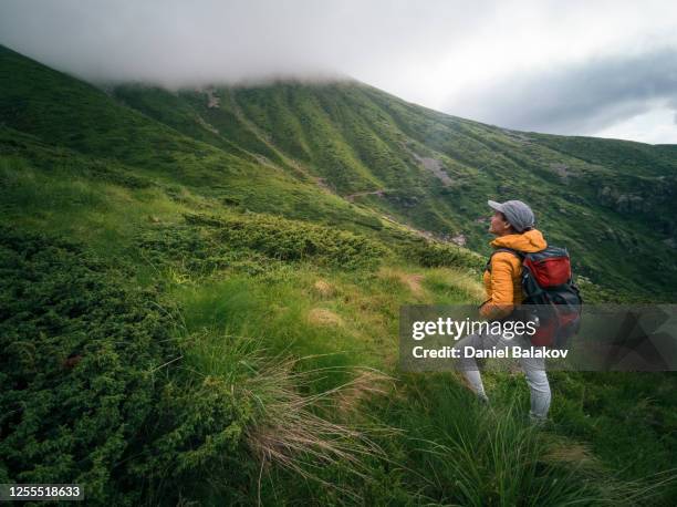 back to nature. woman solo traveler hiking in the mountains. enjoyment outdoors on a sunny day after the covid-19 pandemic. - height stock pictures, royalty-free photos & images