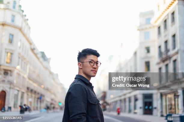 confident young man discovery the city - chinese person stock-fotos und bilder