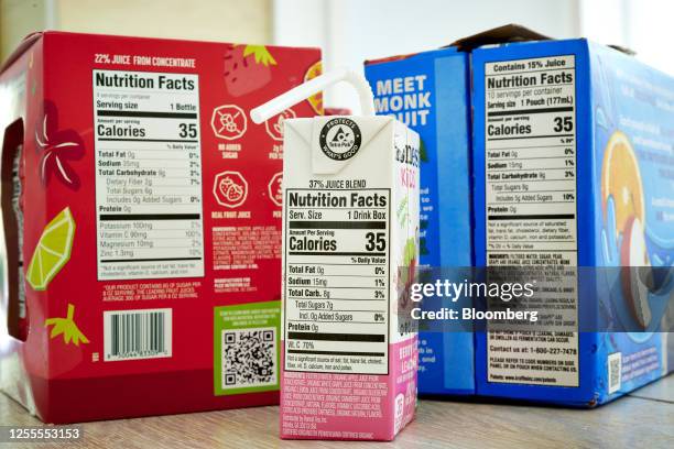 Nutritional labels on a box of Plezi Tropical Punch flavored juice drink blend, Honest Kids Berry Good Lemonade, and Capri Sun Fruit Punch juice...