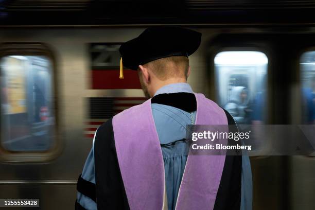 Graduate student waits for a subway ahead of the Columbia University commencement convocation in New York, US, on Wednesday, May 17, 2023. The...