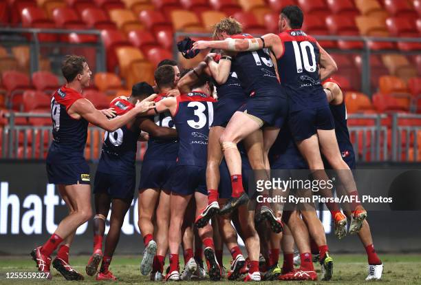 The Demons celebrate after Harley Bennell of the Demons kicked a goal after the final siren during the round 6 AFL match between the Melbourne Demons...