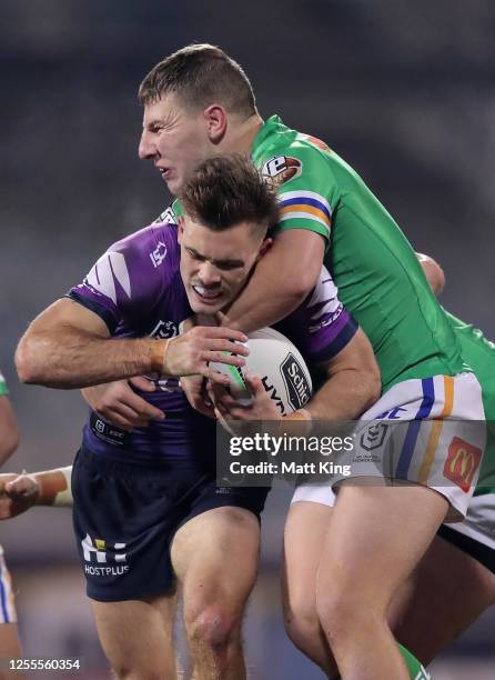 Ryan Papenhuyzen of the Storm is tackled during the round nine NRL match between the Canberra Raiders and the Melbourne Storm at GIO Stadium on July...