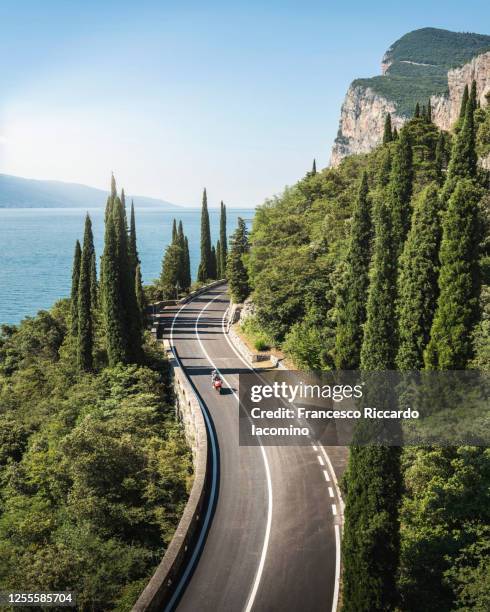 scenic road on lake garda in summertime, blue water and sky. italy - motorbike on road stock pictures, royalty-free photos & images