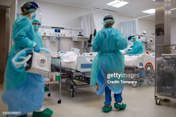 trabajadores del hospital covid con ropa de epi que llegan con un respirador médico. - vista general fotografías e imágenes de stock