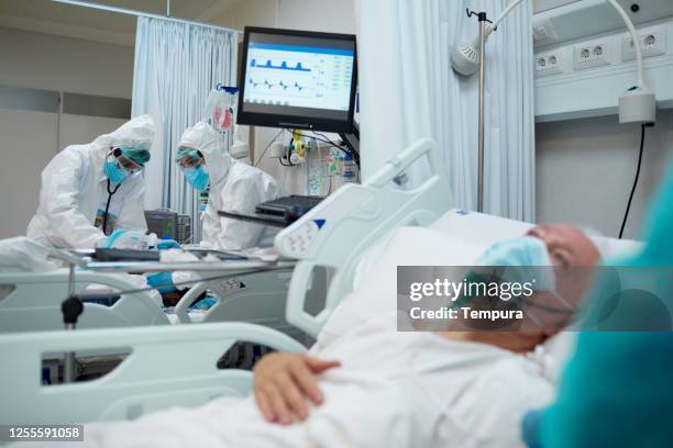 trabajadores sanitarios ajustando la mascarilla de oxígeno a un paciente covid. - intubation fotografías e imágenes de stock