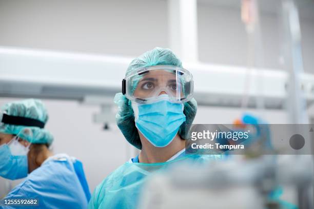 healthcare worker wearing protective mask and glasses in a  hospital covid ward. - protective workwear imagens e fotografias de stock