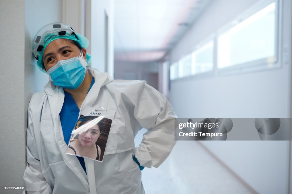 One overworked healthcare workerresting in PPE clothes.