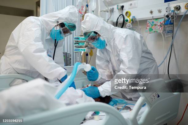 healthcare workers intubating a covid patient. - coronavirus stock pictures, royalty-free photos & images