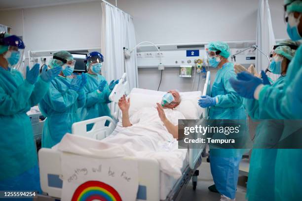 healthcare workers are clapping at a recovered patient. - clapping hands covid stock pictures, royalty-free photos & images