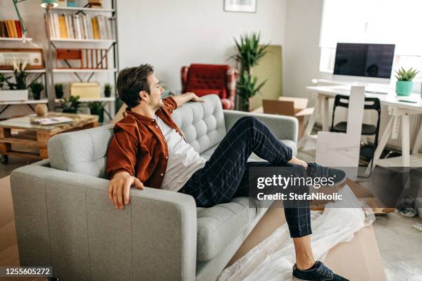 men relaxing on sofa - new sofa stock pictures, royalty-free photos & images