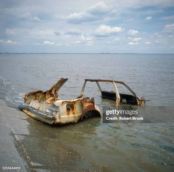 wrecked car in sea at the mouth of the thames estuary, isle of grain. kent, uk - car crash wall stock pictures, royalty-free photos & images