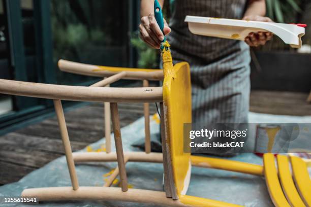 nahaufnahme der hände der frau, die einen stuhl zu hause färbt - holz streichen stock-fotos und bilder