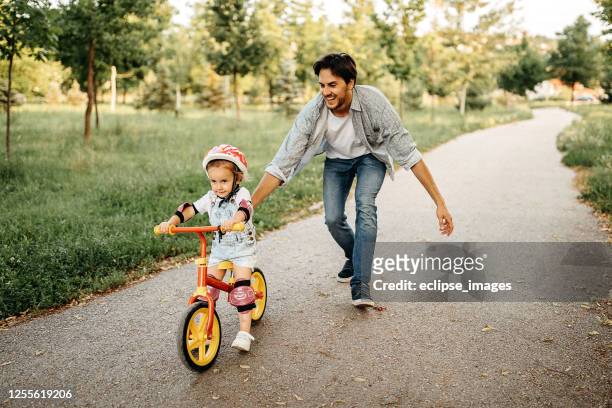 een helpende hand - bicycle daughter stockfoto's en -beelden