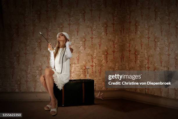 flapper girl sitting on suitcase - 1920s flapper girl imagens e fotografias de stock