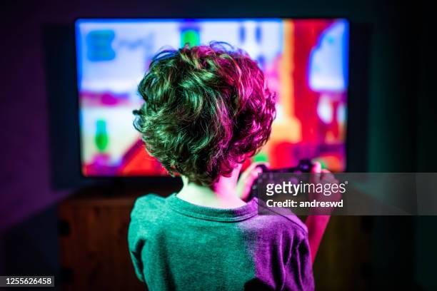 little boy playing video game - gaming imagens e fotografias de stock