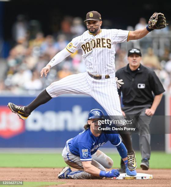 Xander Bogaerts of the San Diego Padres jumps over Bobby Witt Jr. #7 of the Kansas City Royals as he tries to turn a double play during the fourth...