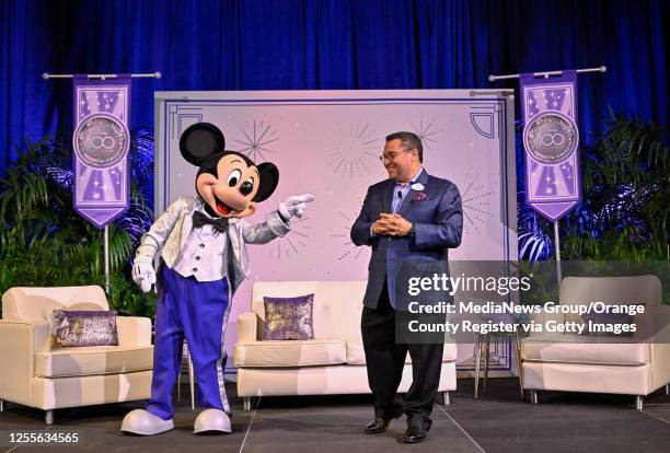 Ken Potrock, president of the Disneyland Resort, stands with Mickey Mouse as he talks about Disney expansion plans during an OC Forum luncheon at the...