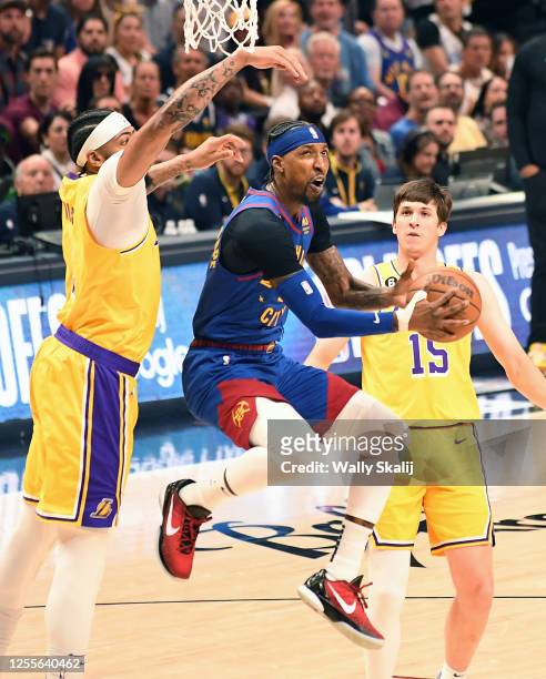 Denver, Colorado May 16, 2023-Nuggets Kentavious Caldwell-Pope drives to the basket against Lakers Anthony Davis, left, and Austin Reaves in Game 1...