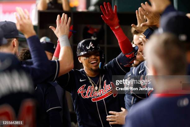 Orlando Arcia of the Atlanta Braves celebrates with teammates in the dugout after hitting the go-ahead home run against the Texas Rangers during the...