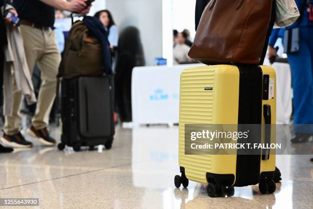 Passenger pushes a carry on suitcase while boarding a flight at Los Angeles International Airport in Los Angeles, California on May 17, 2023.