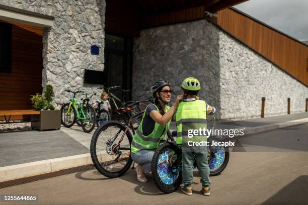 young woman preparing her son for bike riding - high vis stock pictures, royalty-free photos & images