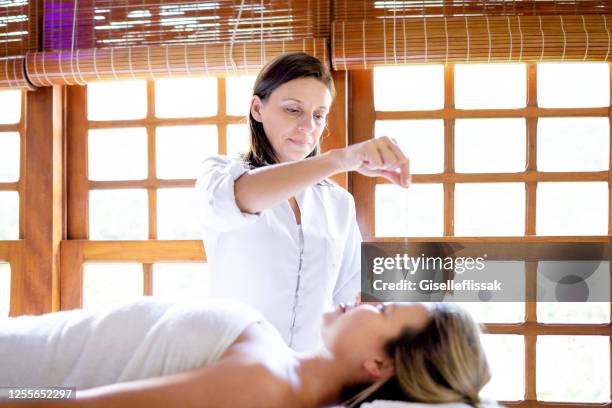 therapist using pendulum to make diagnosis - crystal ly stock pictures, royalty-free photos & images