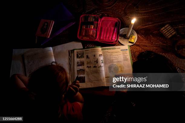 Marina Van Biljon and her daughter, Nika, do homework during loadshedding in Frankfort on May 10, 2023. The single mother says life has become...