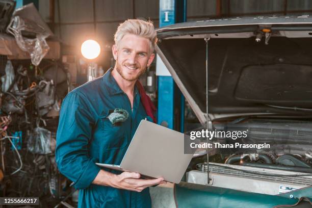 car mechanic using laptop in repair garage - mechatronics stock-fotos und bilder