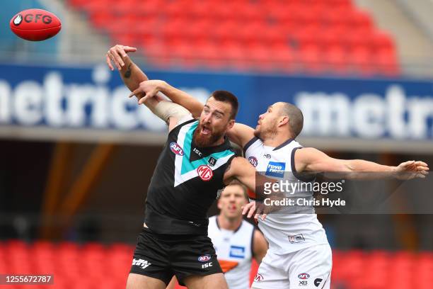 Shane Mumford of the Giants and Charlie Dixon of the Power compete for the ball during the round 6 AFL match between the Port Adelaide Power and the...
