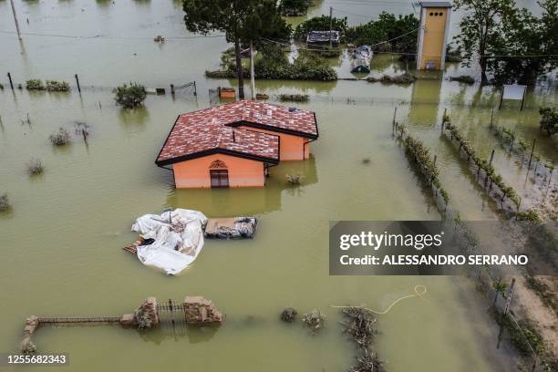 An aerial view taken on May 18, 2023 shows a flooded house in the town of Cesena, after heavy rains caused flooding across Italy's northern Emilia...