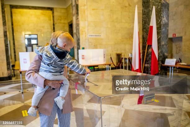 Child casts a ballot during Poland's Presidential elections run off on July 12, 2020 in Warsaw, Poland. The latest polls suggest a close race between...