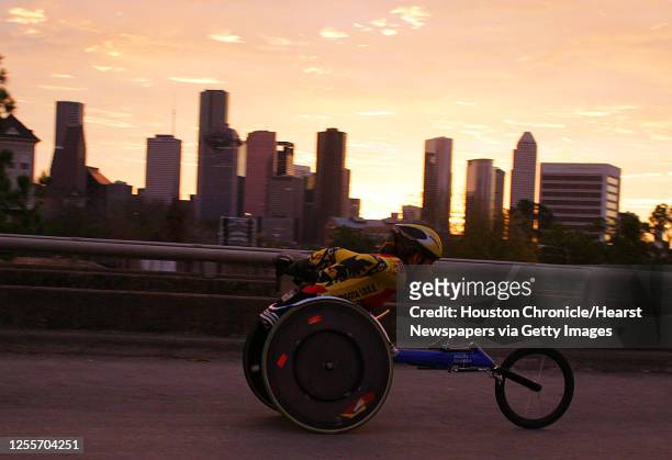 Wheelchair racer paces the downtown Houston skyline as he crosses Memorial drive on the Studewood overpass near mile during the Chevron Houston...