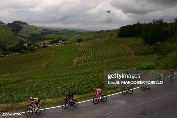 Overall leader INEOS Grenadiers's British rider Geraint Thomas and the pack of riders cycle past the village of Barolo, which vineyards have been...